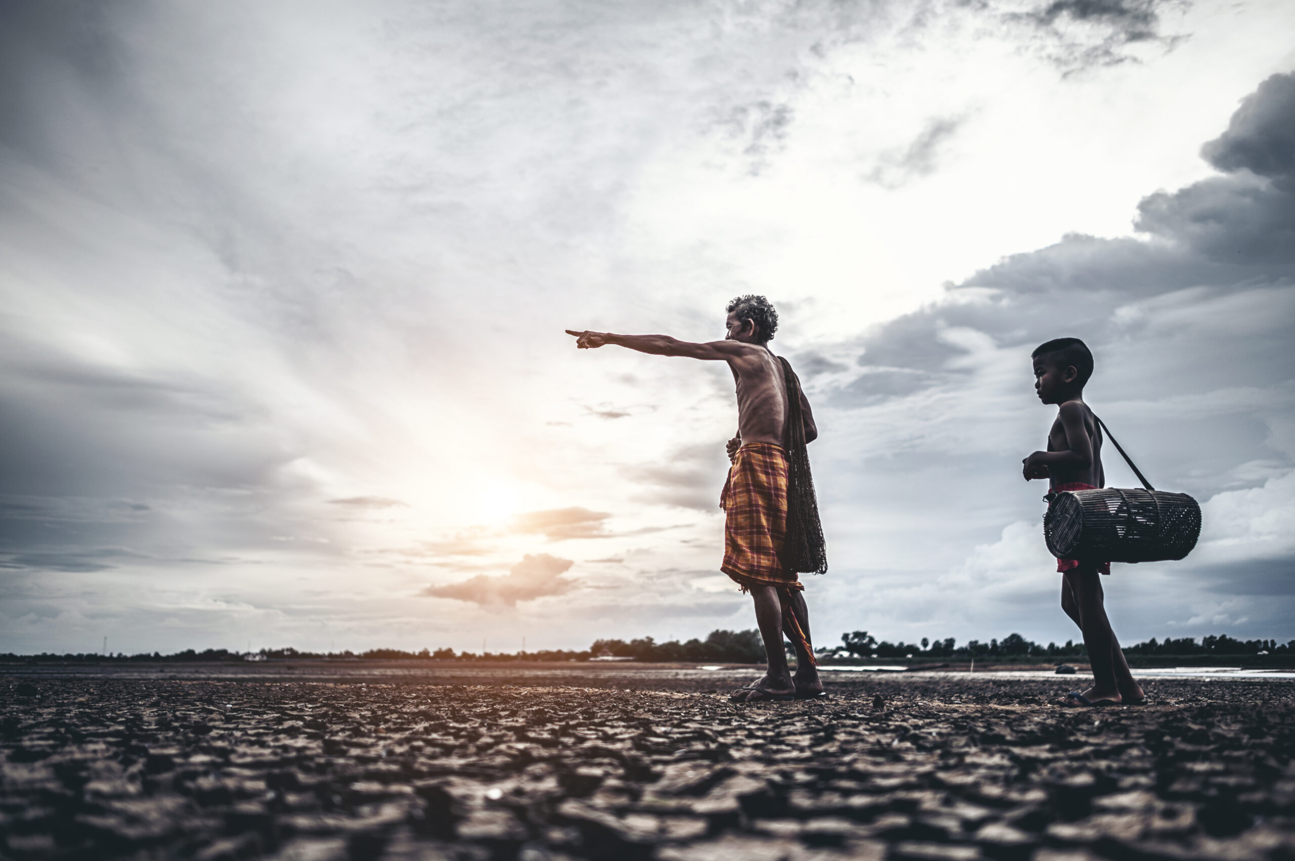 Elderly men and boy find fish on dry ground,global warming